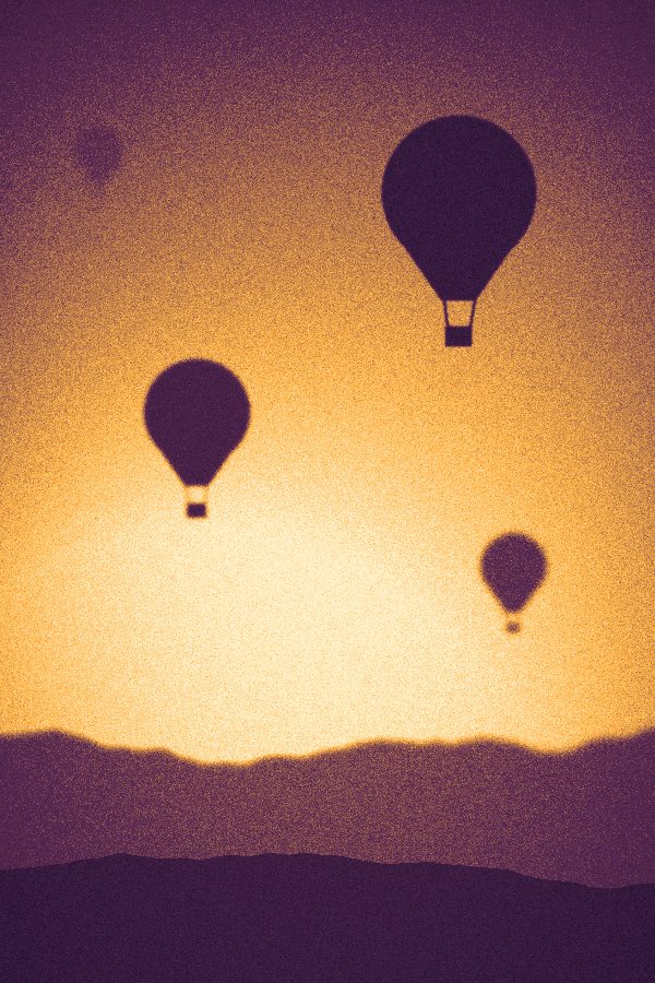 Montgolfières au-dessus d'une vallée dans une lumière dorée